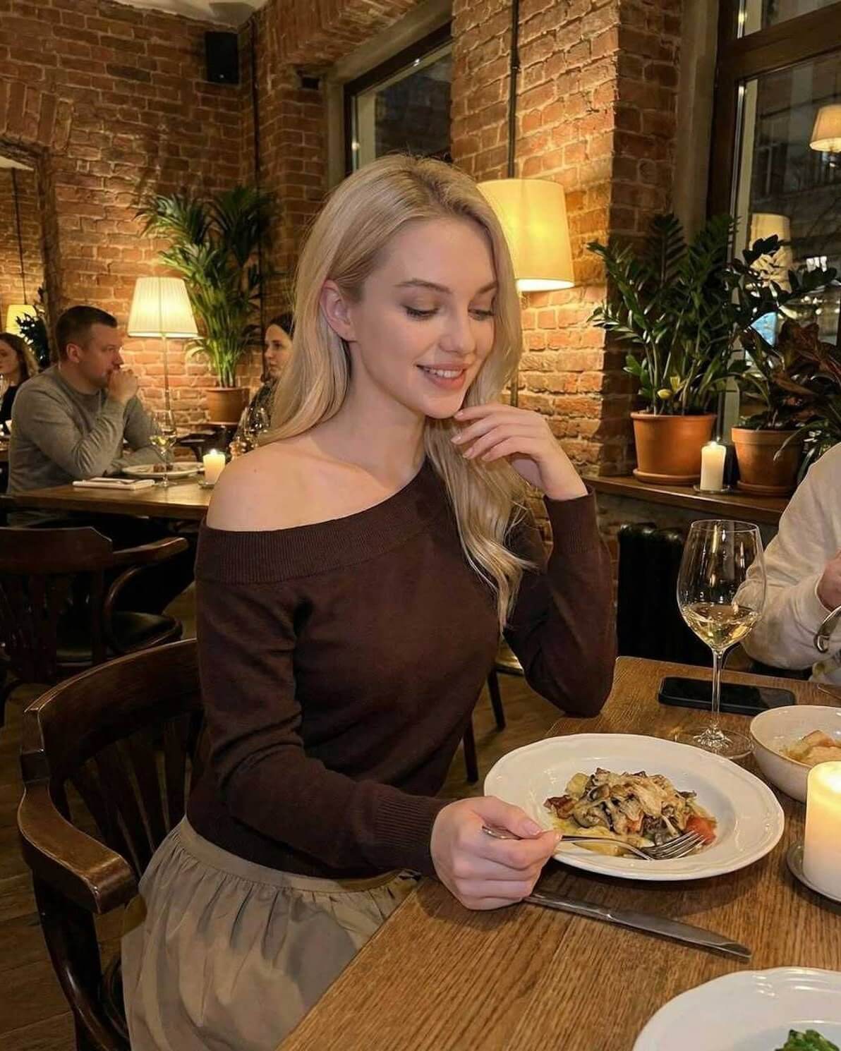 Verona Pullover by Lauven – Women’s brown off shoulder sweater styled at a cozy restaurant.