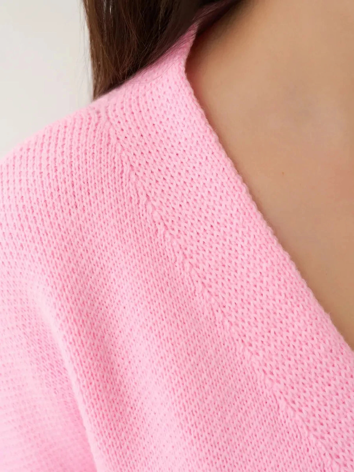 Close-up of the Celeste Cardigan by Lauven, featuring a soft pink knit fabric and refined neckline.