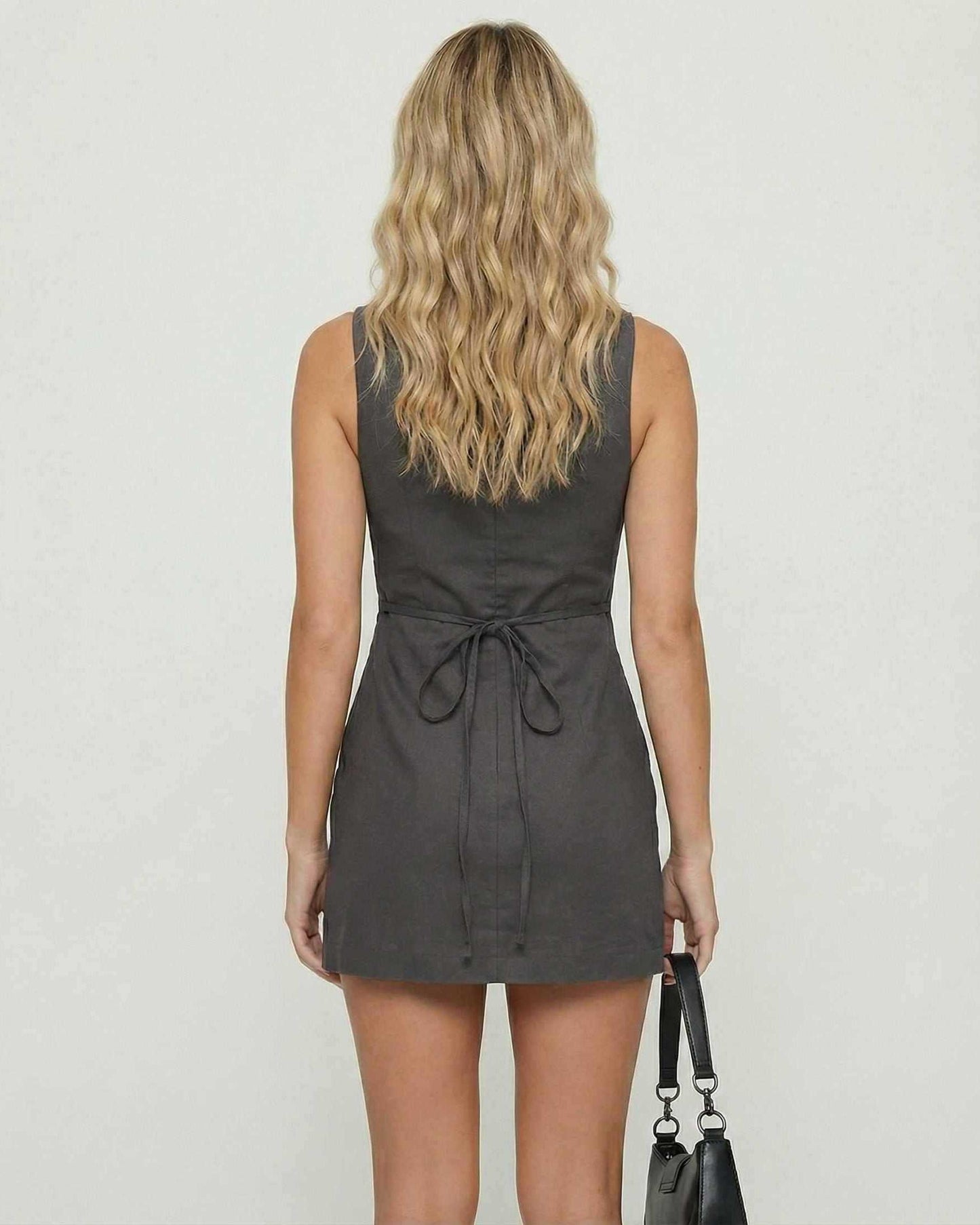 Back view of the Slate Mini Dress by Lauven, featuring a sleeveless charcoal bodycon design and back tie.