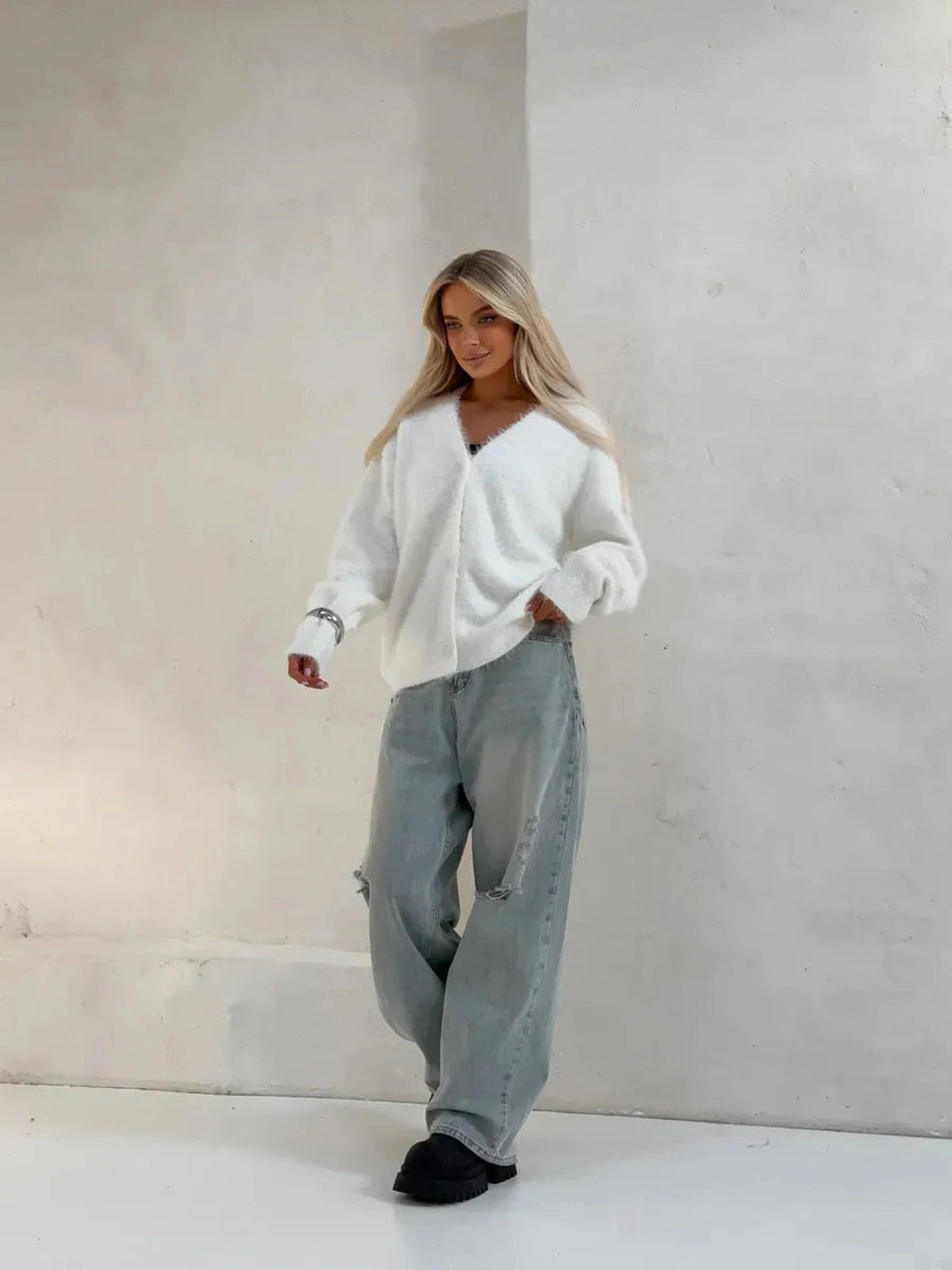 Model wearing the Luna Cardigan by Lauven, an oversized white fluffy knit cardigan with button closure.