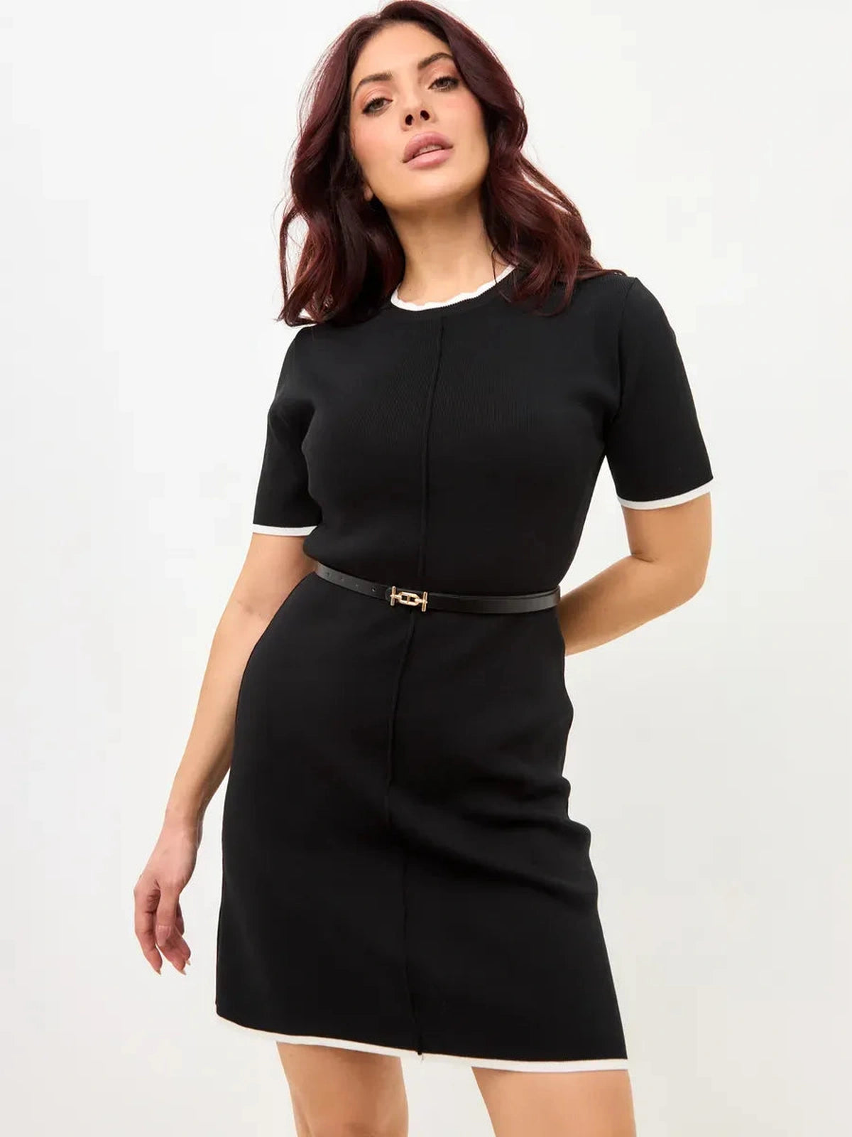 Elegant woman in Solara Mini Dress by Lauven, featuring sleek contrast trim and a stylish belt.