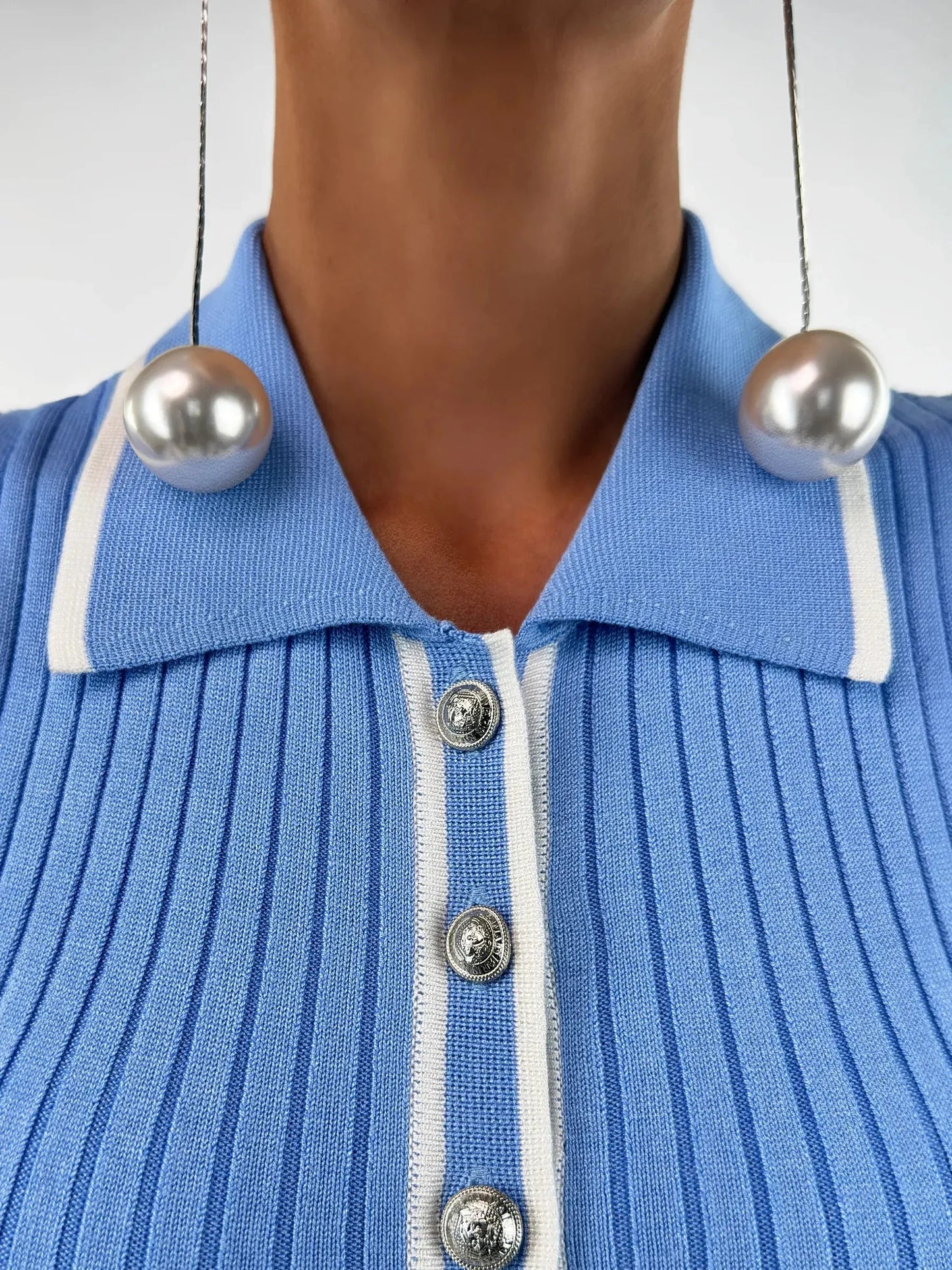 Close-up of the Celeste Midi Dress by Lauven, featuring a ribbed knit texture and sky blue color with pearl earrings.