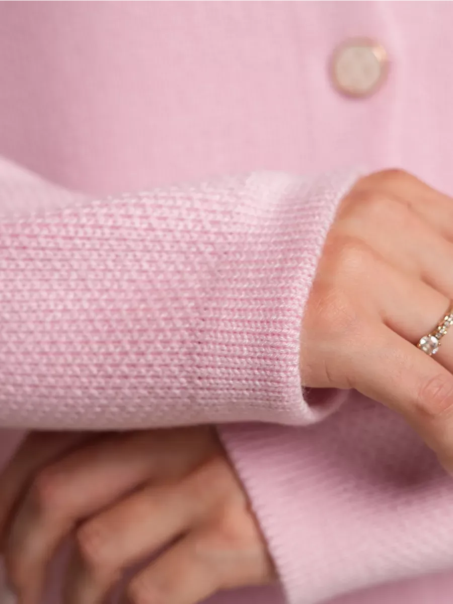 Blush Cardigan by Lauven showing a close-up of the textured sleeve and decorative button in soft pink knit.