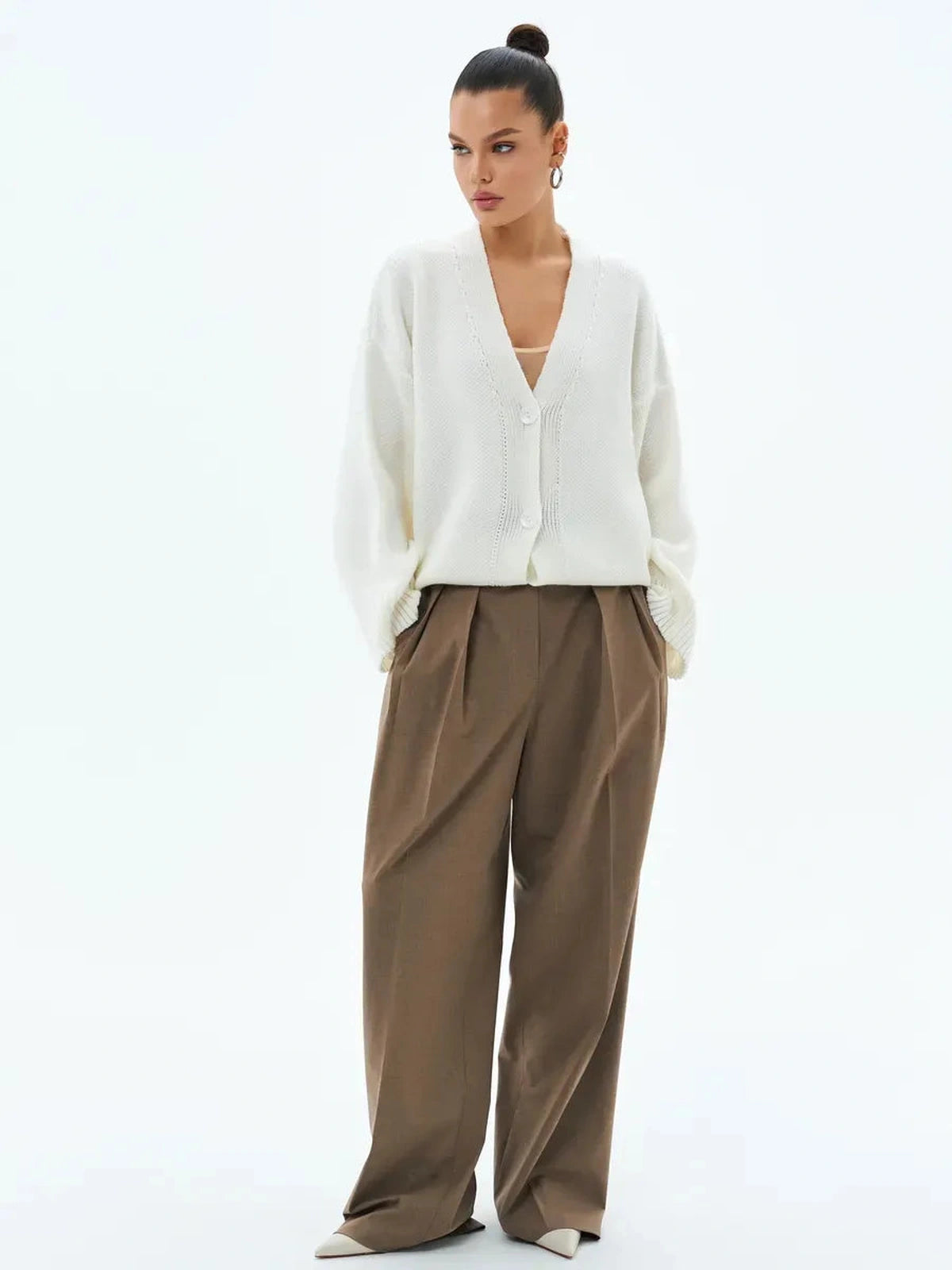 Stylish woman wearing an Ivory Cardigan by Lauven, featuring a button closure and oversized fit.