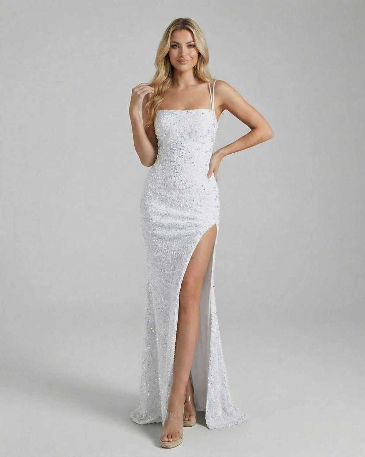 Model wearing the Aria Maxi Dress by Lauven, a white sequin floor-length gown with a thigh-high slit.