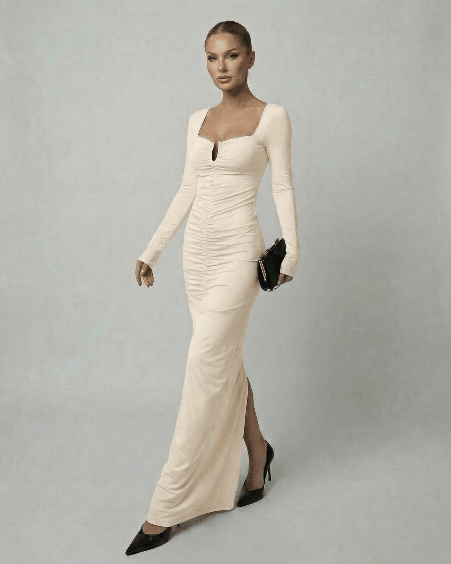 A model wearing the Lauven Astra Maxi Dress, a long sleeve square neck beige maxi dress with high-waist design.