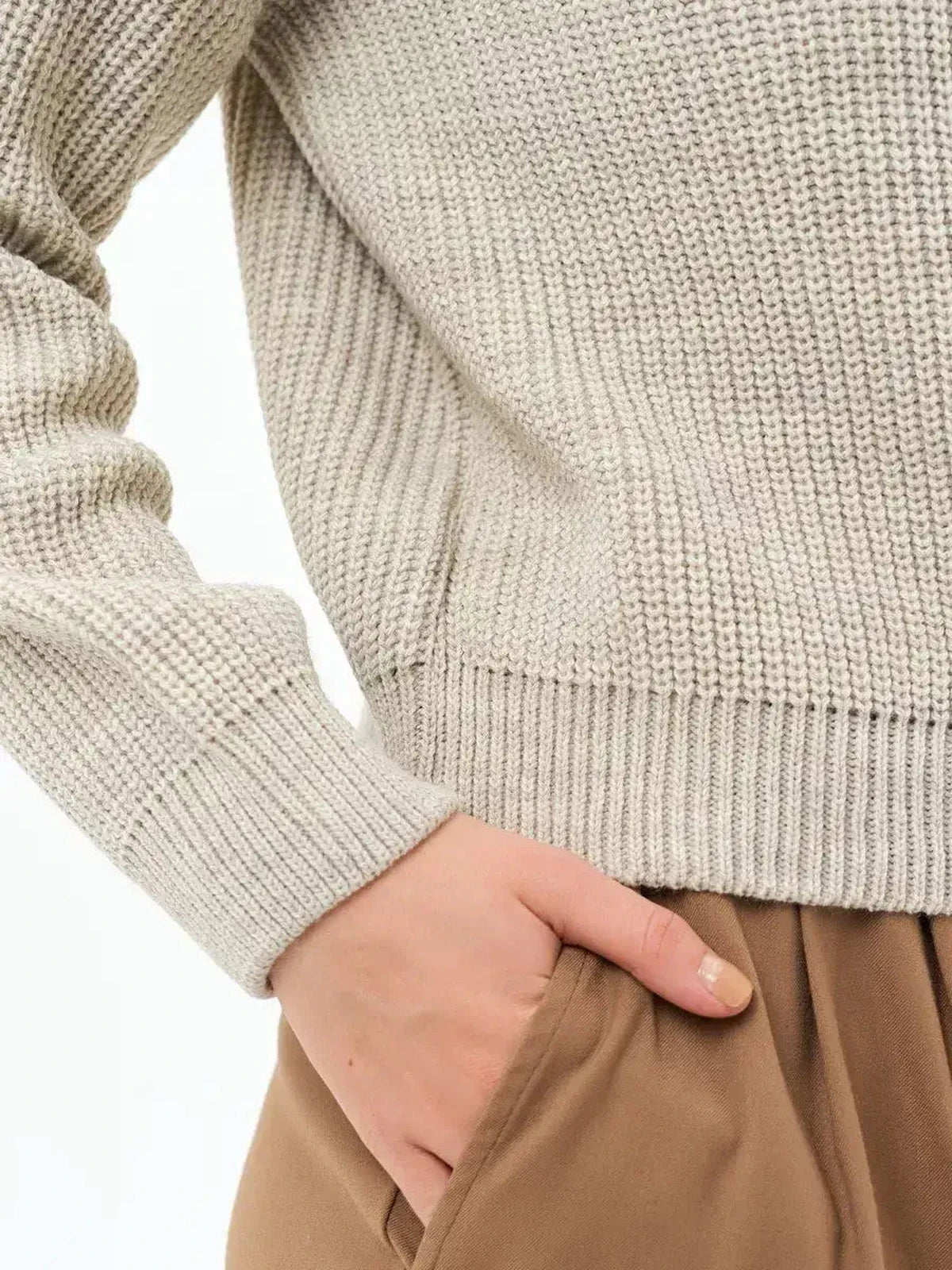 Detail of the Astra Sweater by Lauven, showcasing the soft rib-knit texture and elegant light beige color.