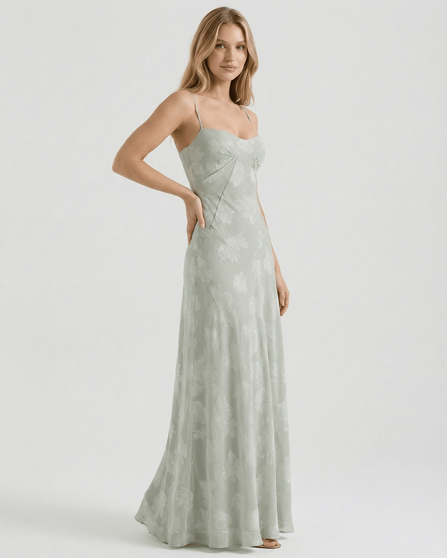 Eliara Maxi Dress by Lauven in soft sage-green with floral print, featuring a sheer lace-up back and elegant silhouette.