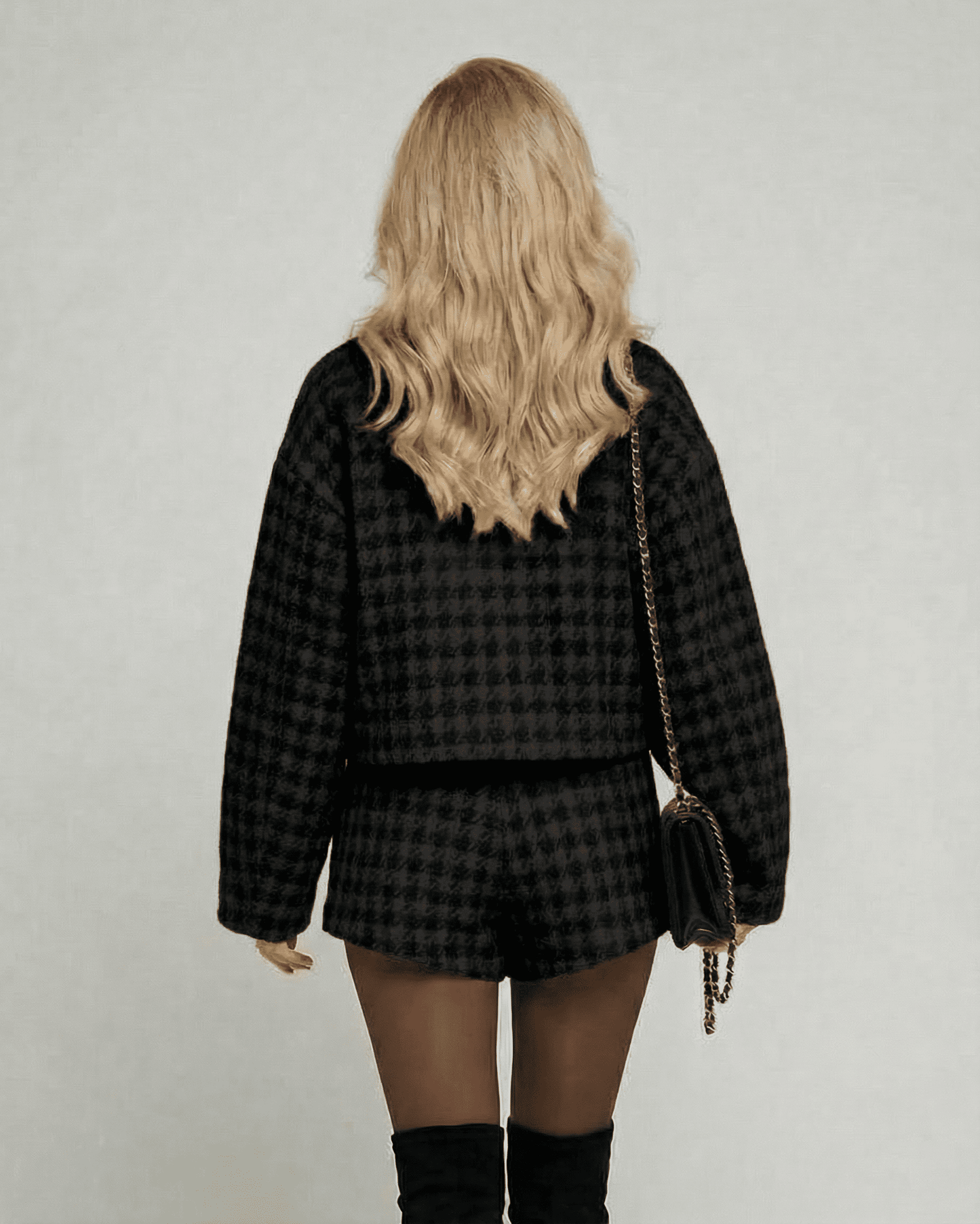 Back view of a model wearing the Noir Set from Lauven, featuring elegant tailored shorts and a chic long-sleeve top.
