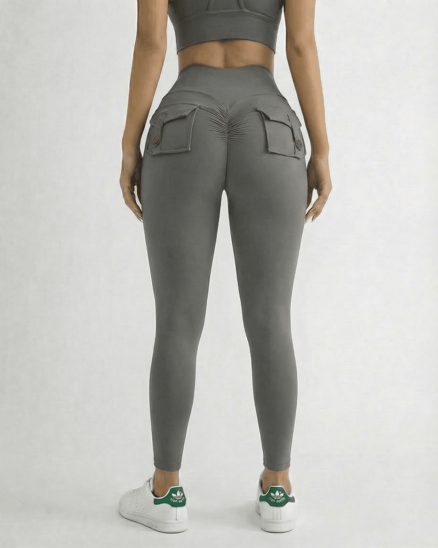 Back view of a model wearing Lauven Slate Leggings with pockets, high waist, and ankle length design.