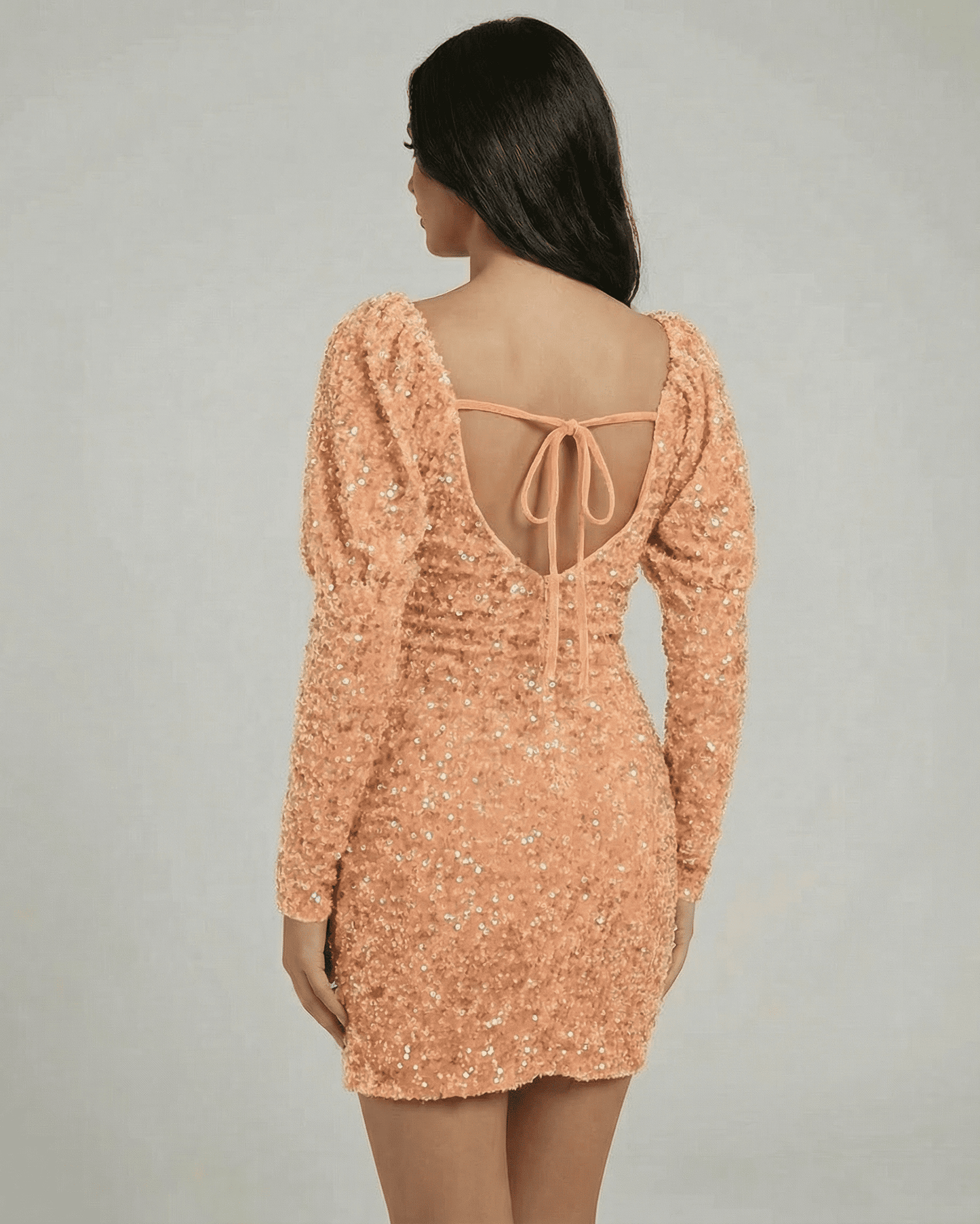Solara Mini Dress by Lauven, back view showcasing peach sequin sheath and open back design with puff sleeves.