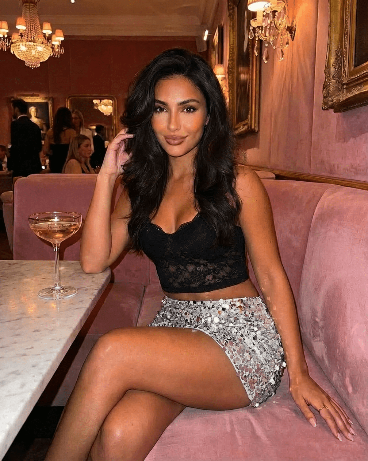 Model wearing Sterling Mini Skirt by Lauven with silver sequin hem, posed elegantly at a chic venue.