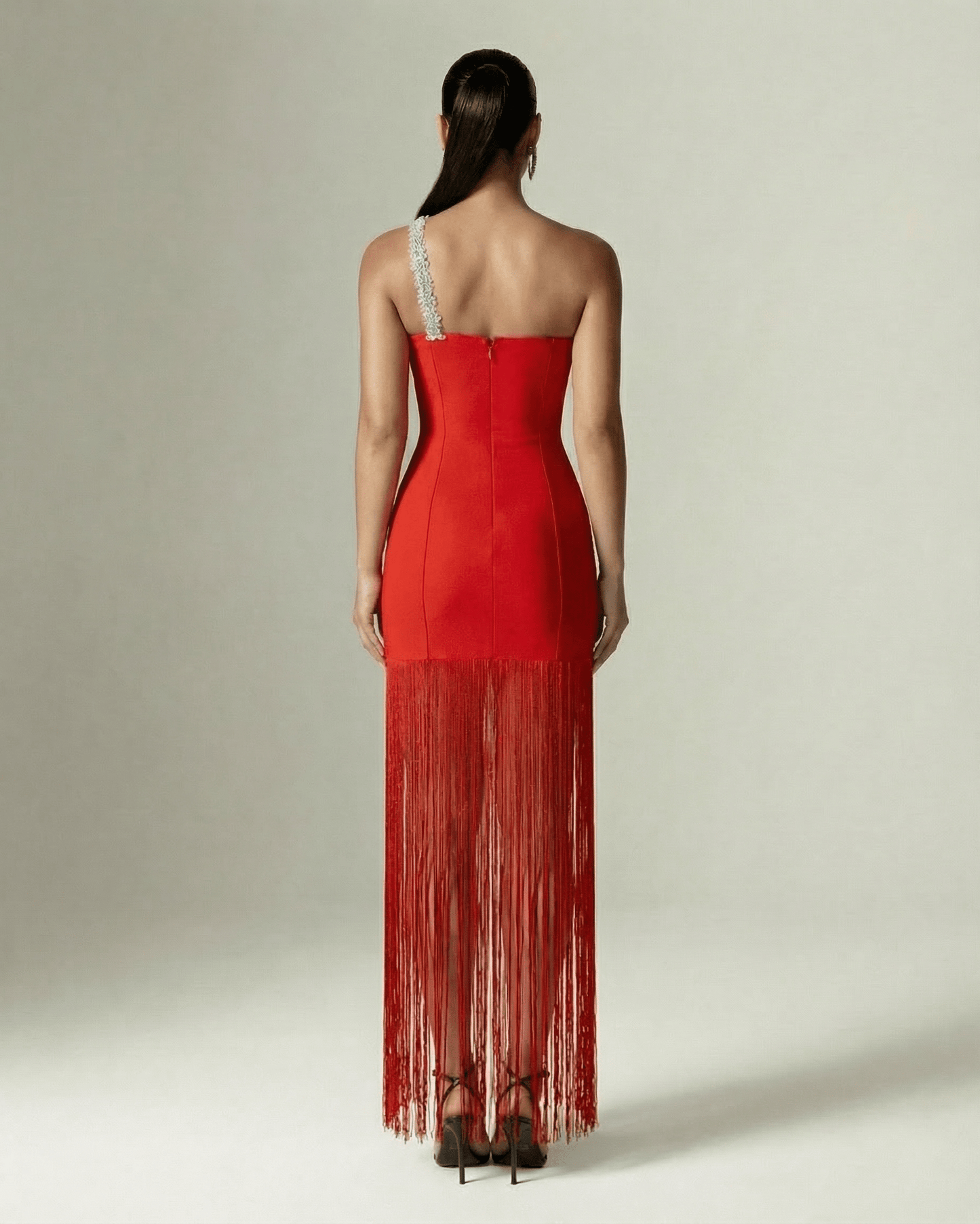 Back view of Lauven Valencia Maxi Dress, featuring a red one-shoulder design and elegant fringe hem.