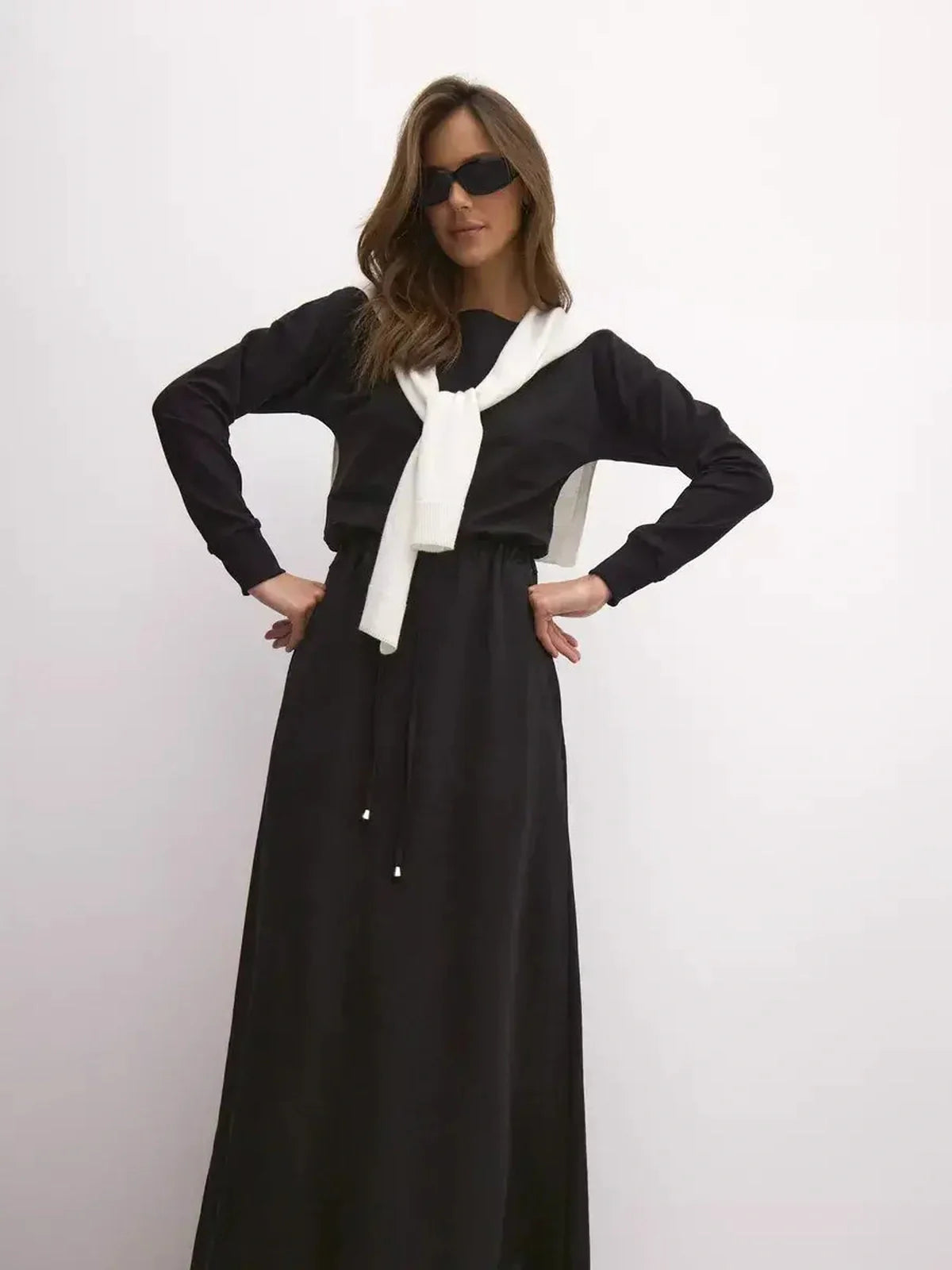 Model showcasing the sleek Maxi Dress Eclipse with a cinched waist and elegant boat neckline, styled for urban fashion.