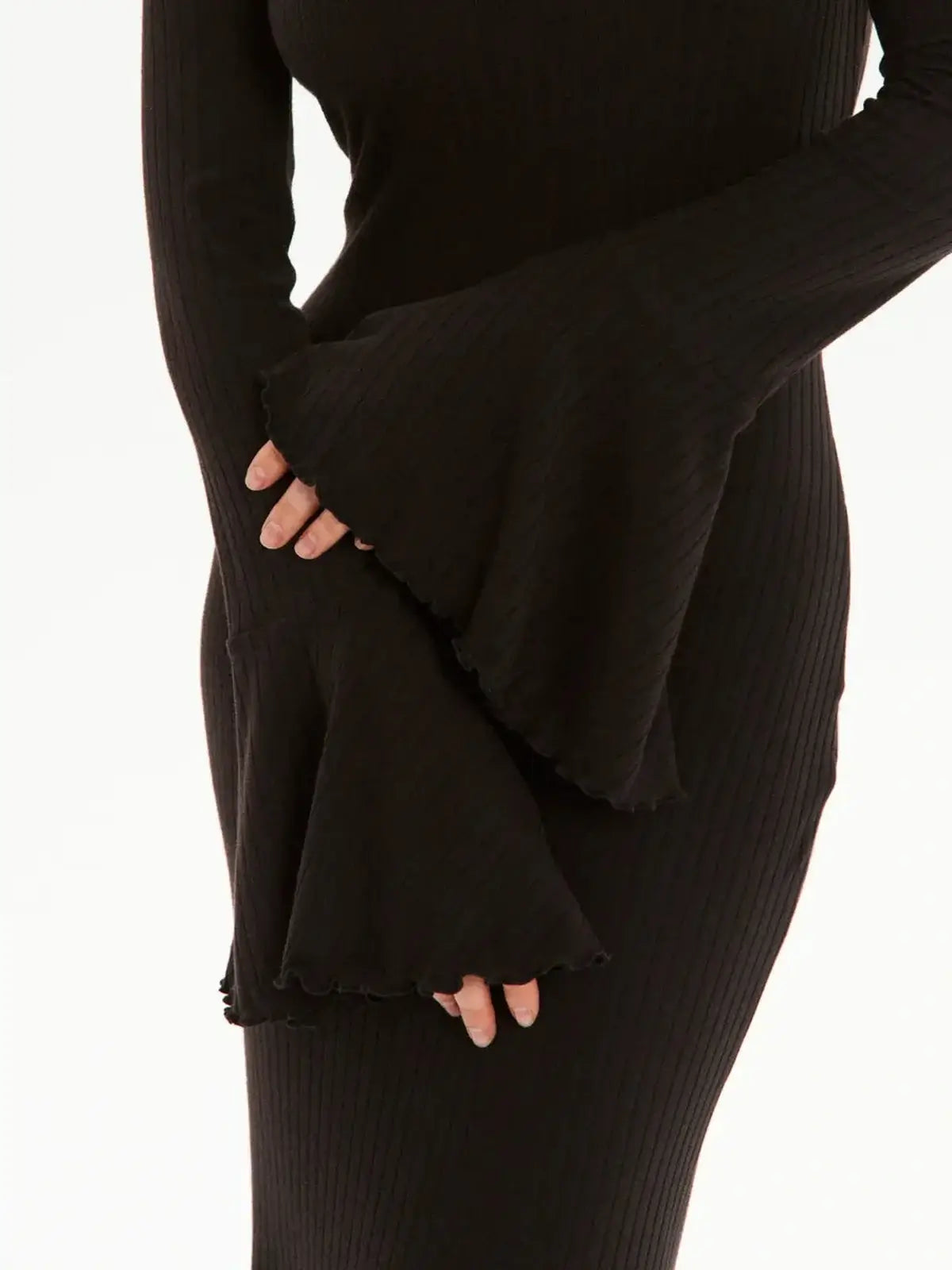 Close-up of the elegant bell sleeves of a black midi dress, showcasing a ribbed knit texture.