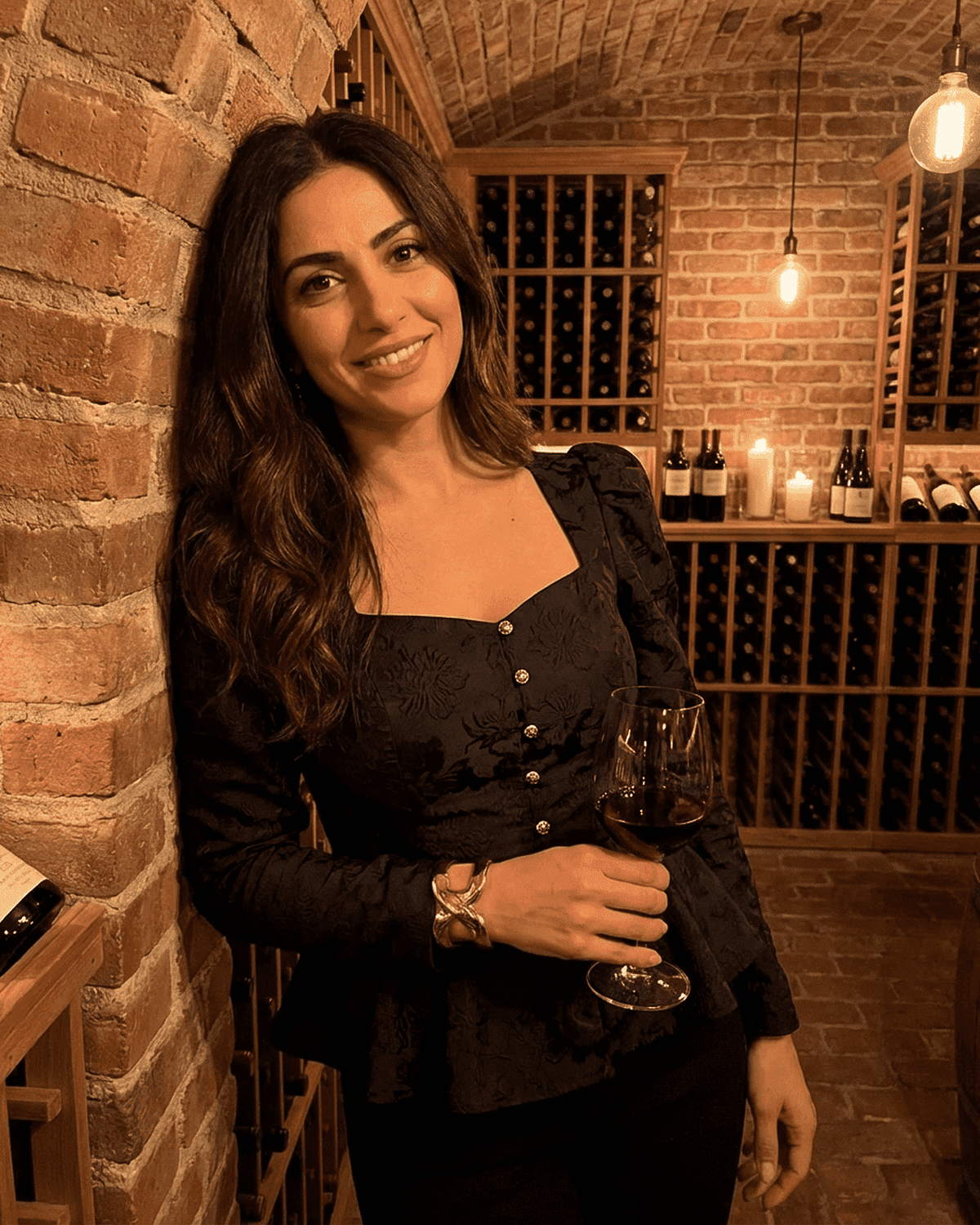 Noir Corset Top by Lauven, featuring a square neck and puff sleeves, elegantly worn with a glass of wine in a wine cellar.