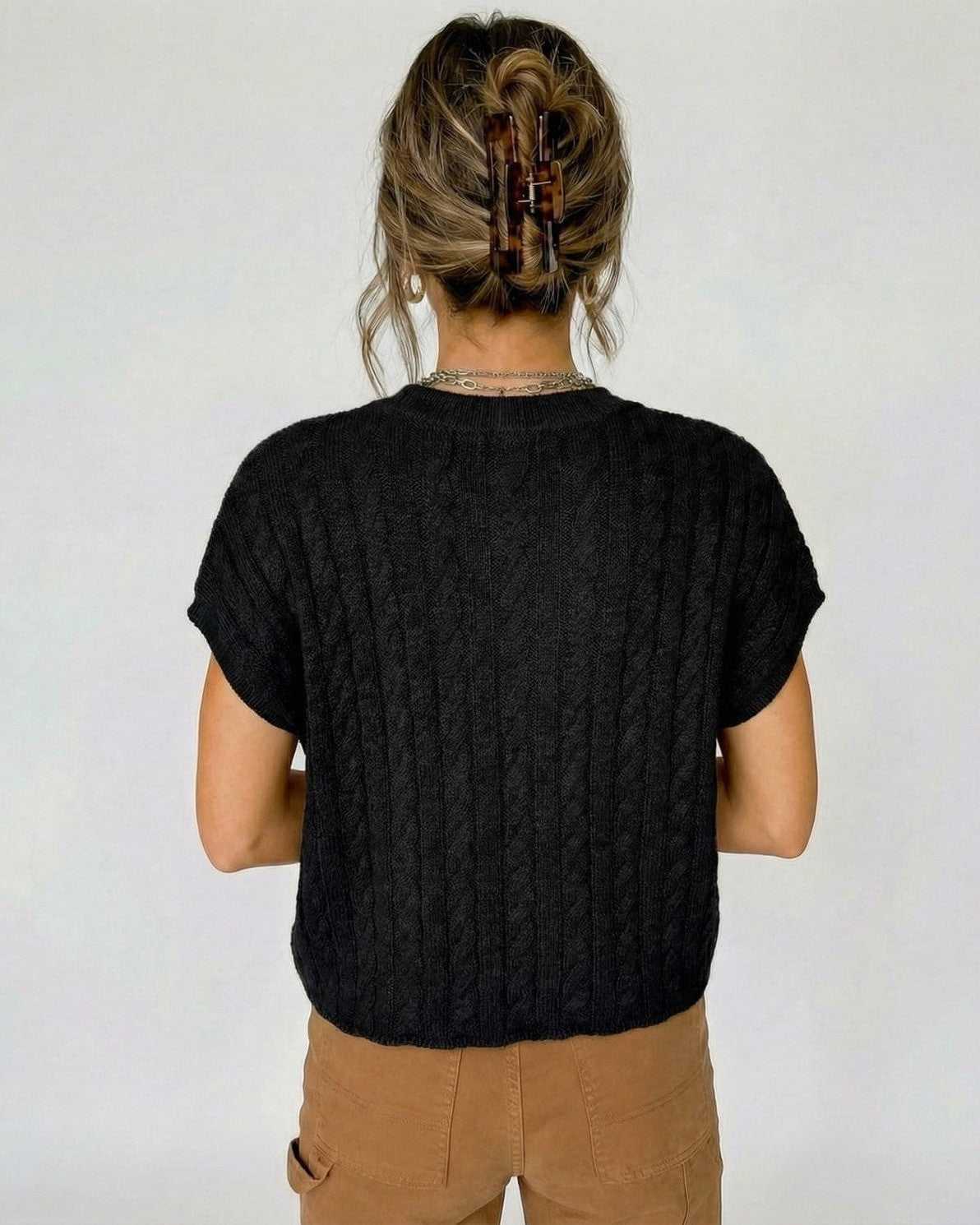 Back view of a woman wearing the Ravenna Sweater by Lauven, showcasing its stylish cable knit design.