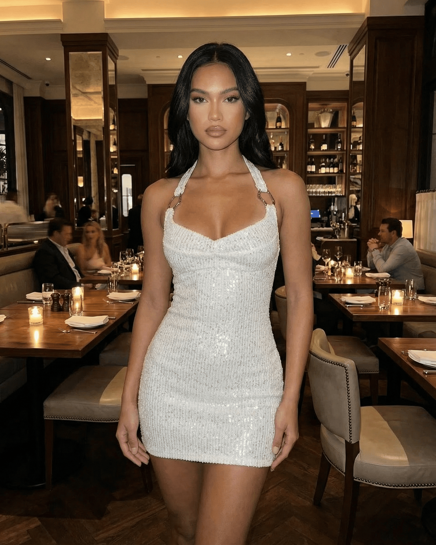 Serena Mini Dress by Lauven, showcasing a white sequin bodycon silhouette in an elegant restaurant setting.