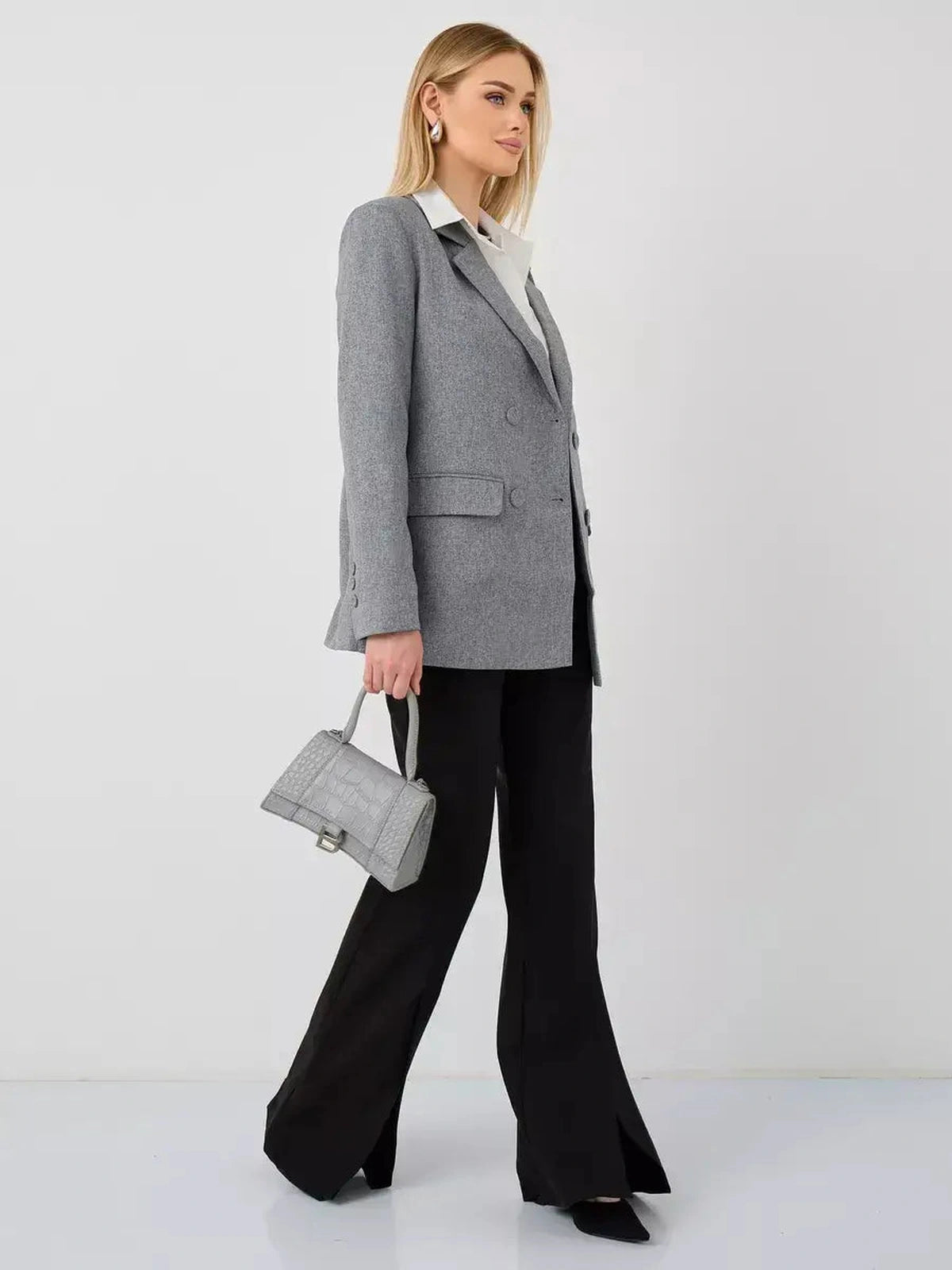 Model showcasing the Silverstone Blazer by Lauven, an oversized double-breasted gray jacket, paired with black pants.