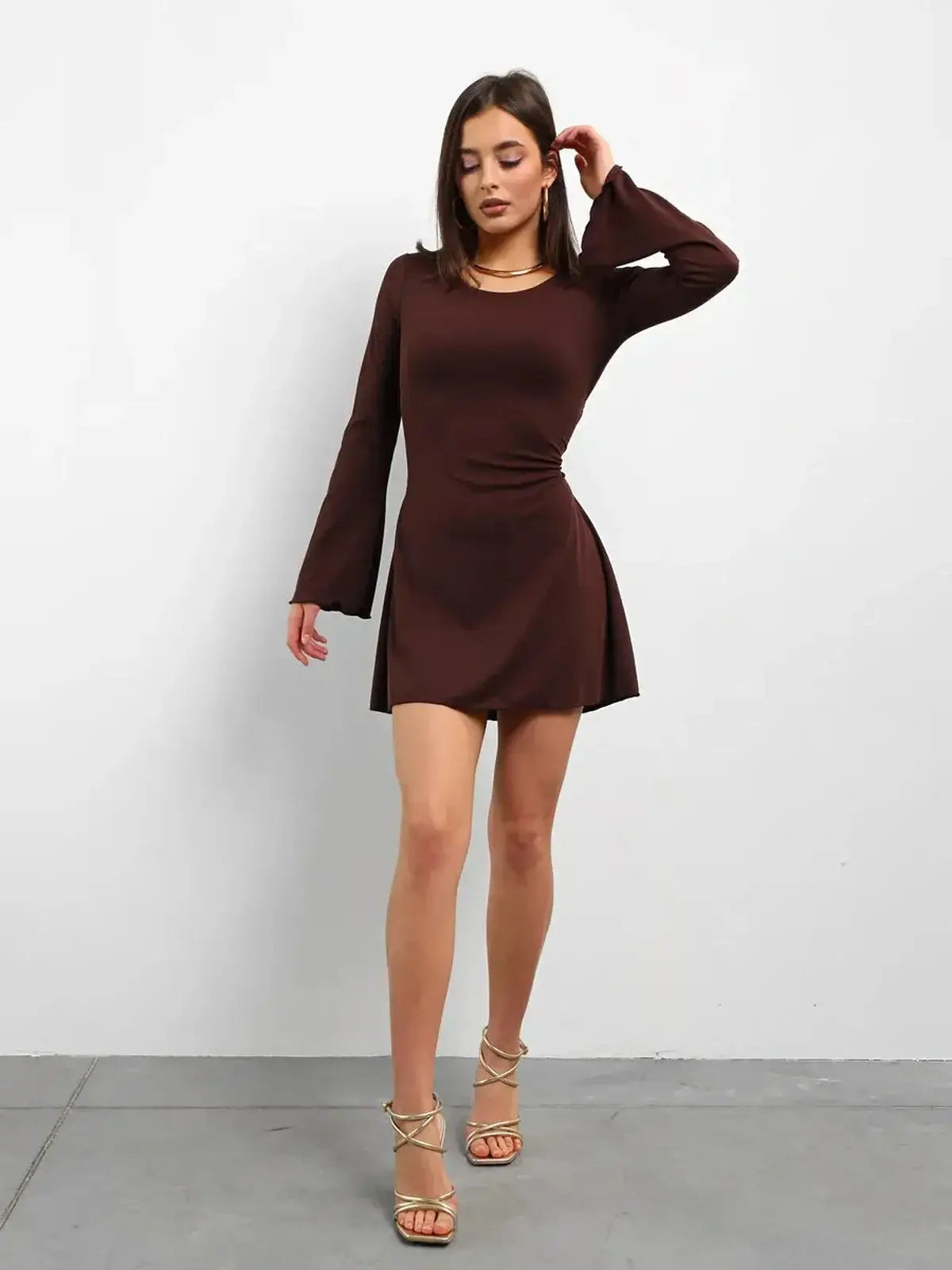 Model wearing a Cocoa Laced long sleeve mini dress in rich chocolate color, perfect for cocktail and wedding guest occasions.