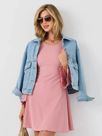 Model wearing the Blush Flare mini dress with a denim jacket and sunglasses, showcasing soft elegance and sculpted style.