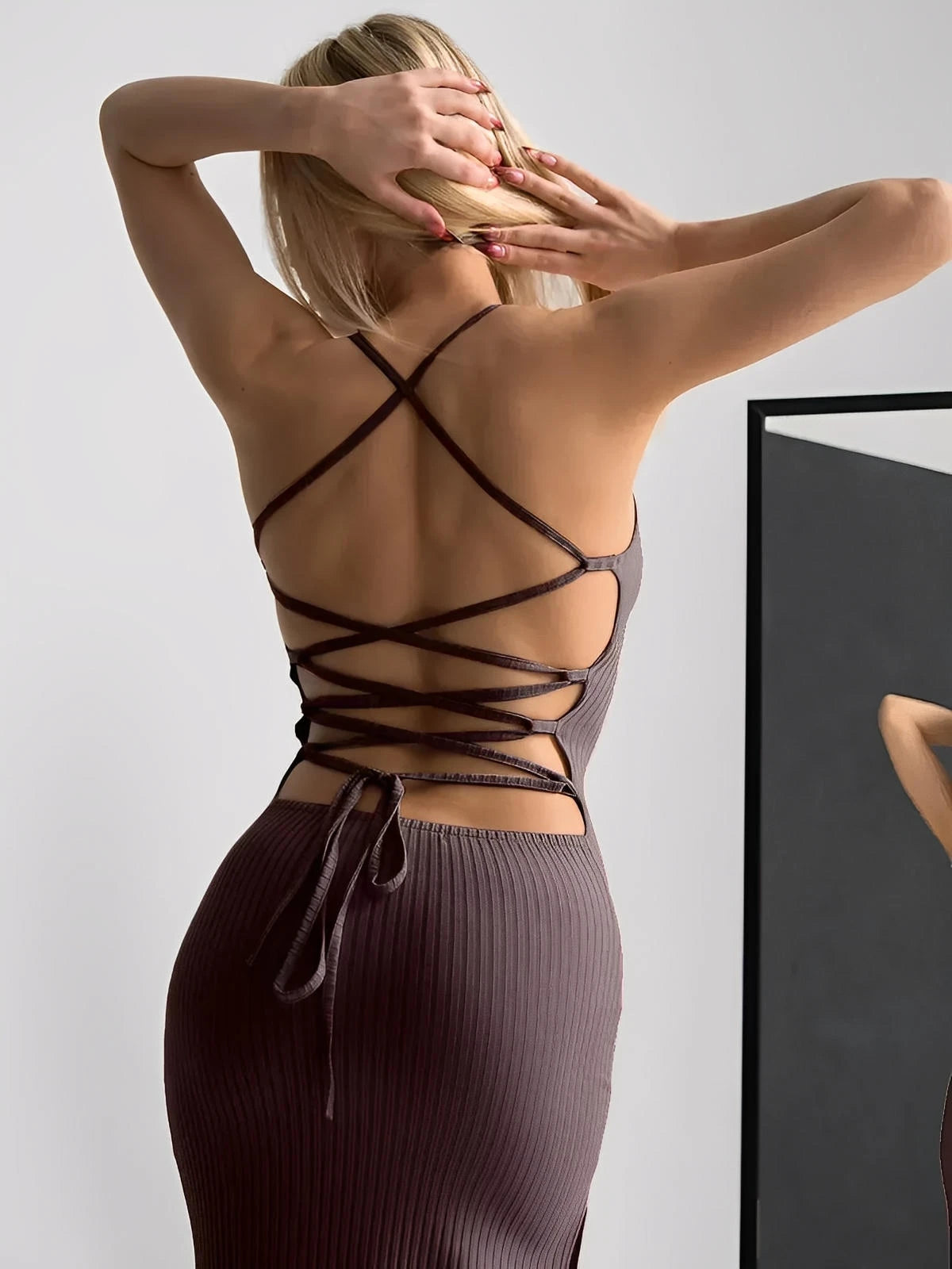 Elegant Obsidian Midi Dress showcasing a strappy back and body-contouring fit, perfect for warm-weather events.