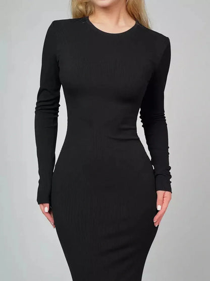 Model wearing the Sculpted Elegance Maxi Dress, a black seamless long sleeve gown designed for a flattering fit.