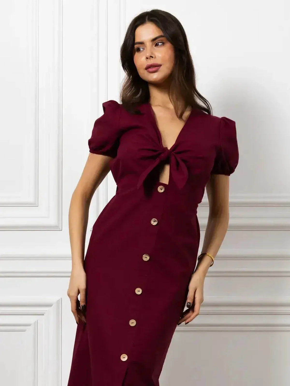 Maxi Dress Merlot Grace in burgundy with front bow, button detail, and puff sleeves for an elegant fit.