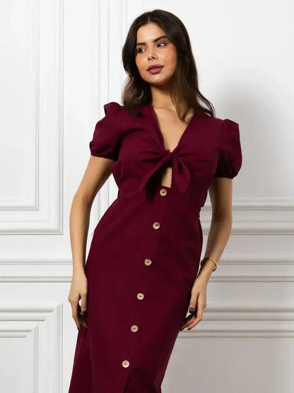 Maxi Dress Merlot Grace in burgundy with front bow, button detail, and puff sleeves for an elegant fit.