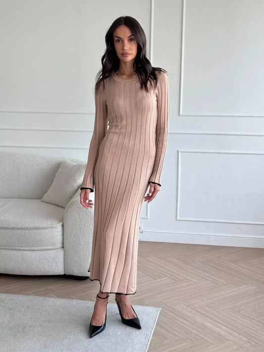 Model wearing Sahara Curve Maxi Dress in sandstone beige, showcasing soft ribbed texture and elegant full-length cut.