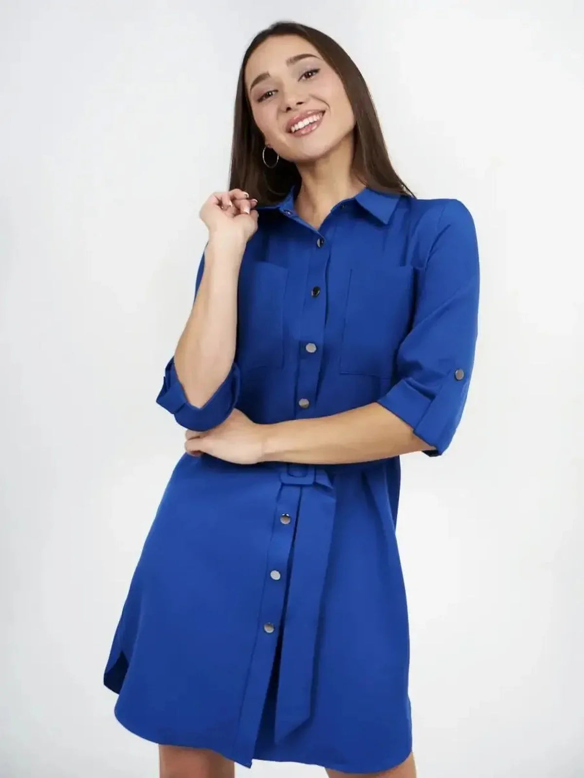 Woman wearing a cobalt blue mini dress with a button-front and adjustable waist, showcasing elegant style and confidence.