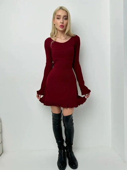 Model wearing a crimson red mini dress with romantic ruffles and fitted bodice, paired with knee-high black boots.
