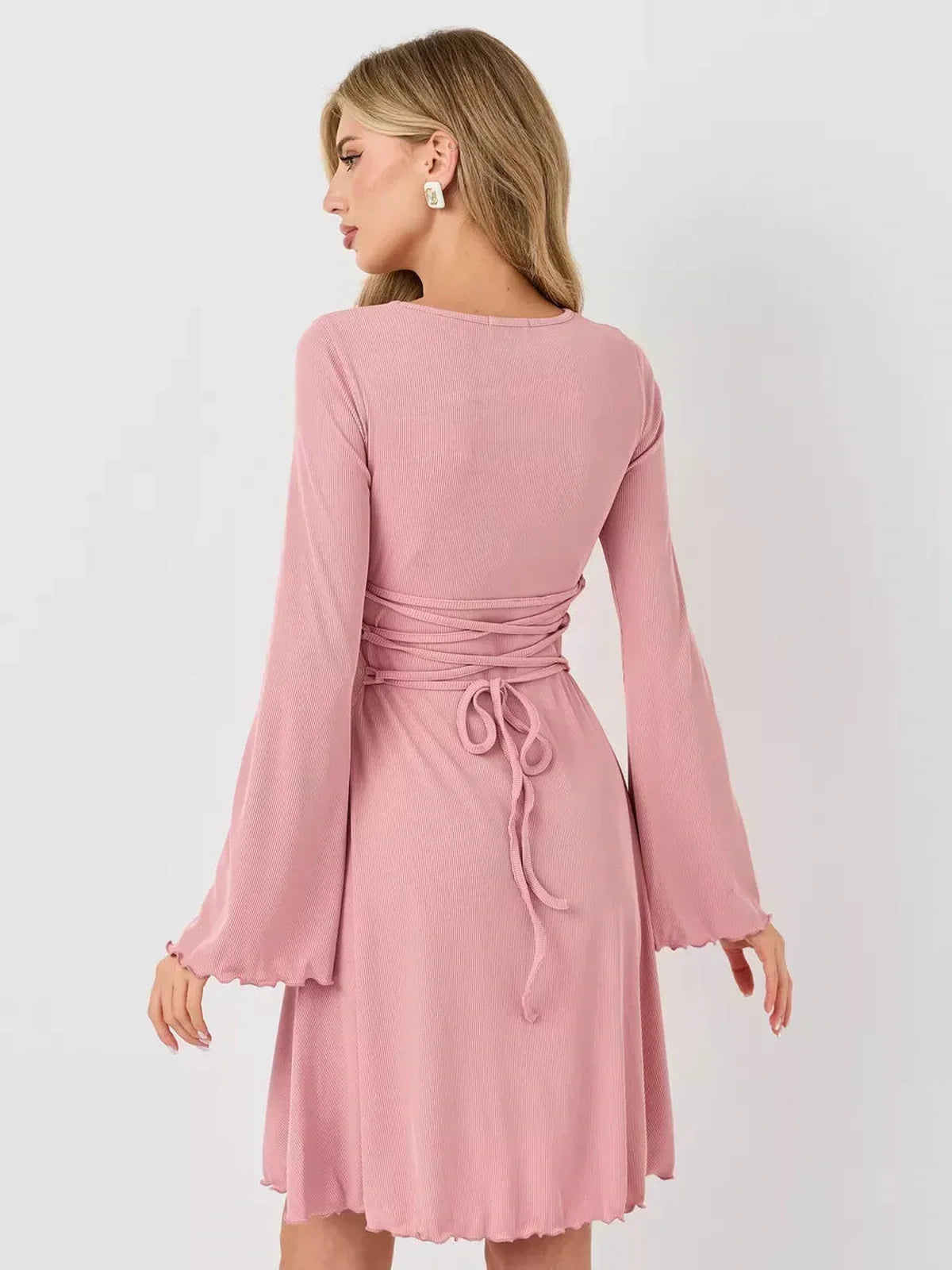 Back view of the Blush Whisper summer dress featuring flared sleeves and a tied waist design in soft pink.