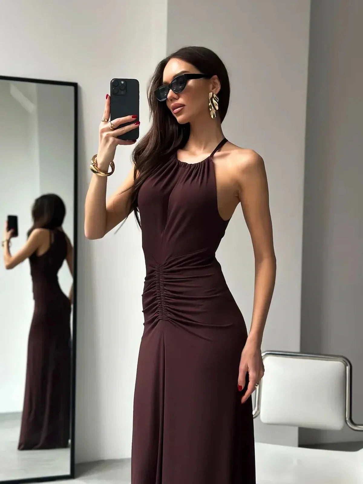 Model wearing Maxi Dress Sienna with halter neckline and ruched detail, reflecting modern elegance and style.