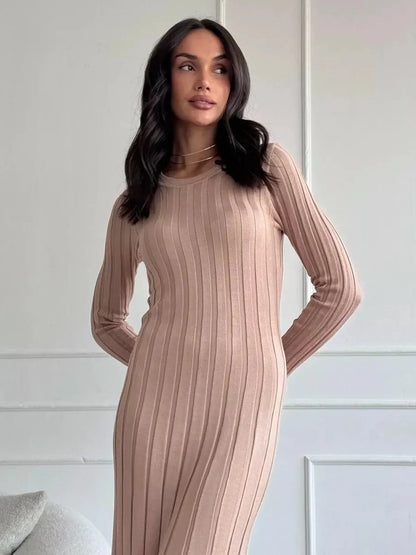 Model showcasing the Sahara Curve Maxi Dress in sandstone beige with a soft ribbed texture and full-length cut.