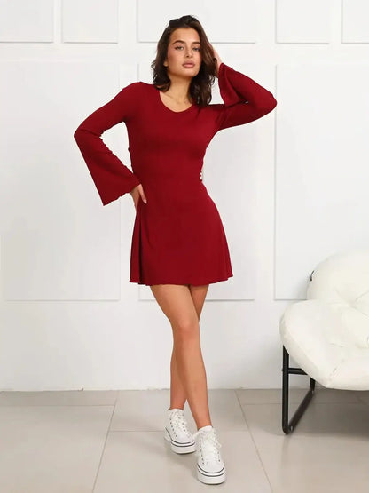 Model wearing a ruby red mini dress with long bell sleeves and a playful silhouette, perfect for summer outings.