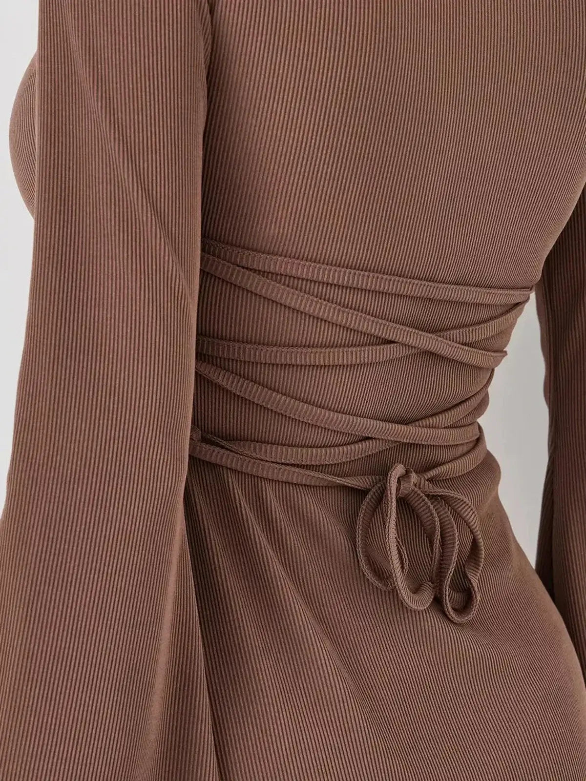 Close-up of Mocha Flare mini dress showing detailed tie-back design and soft flared long sleeves in rich coffee tone.