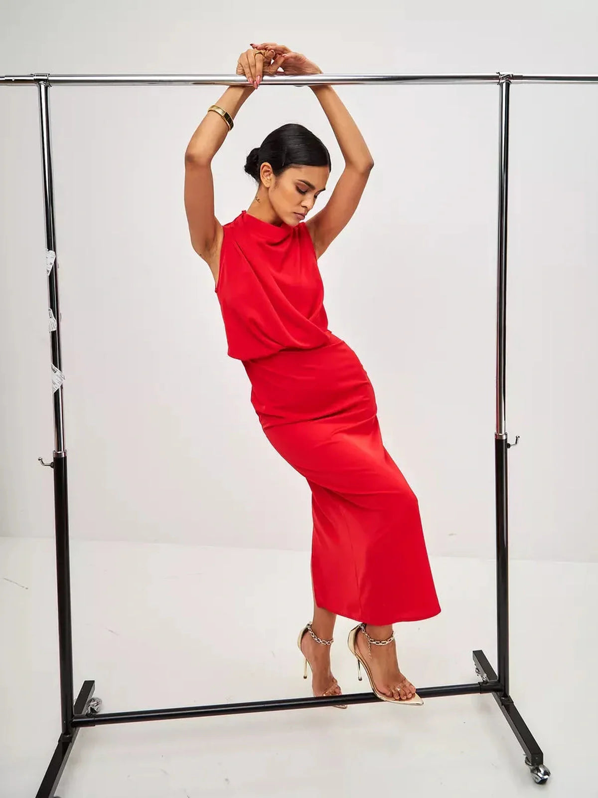 Model showcasing a red drape maxi dress with a sophisticated silhouette and elegant neckline, perfect for formal events.