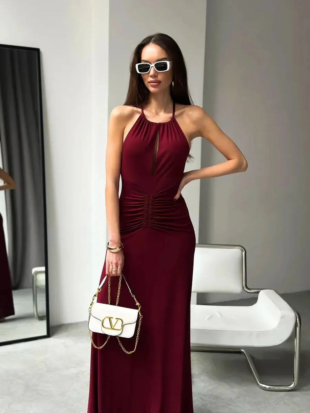 Model wearing Maxi Dress Élan, showcasing draped halter design and ruched waist, perfect for evening occasions.