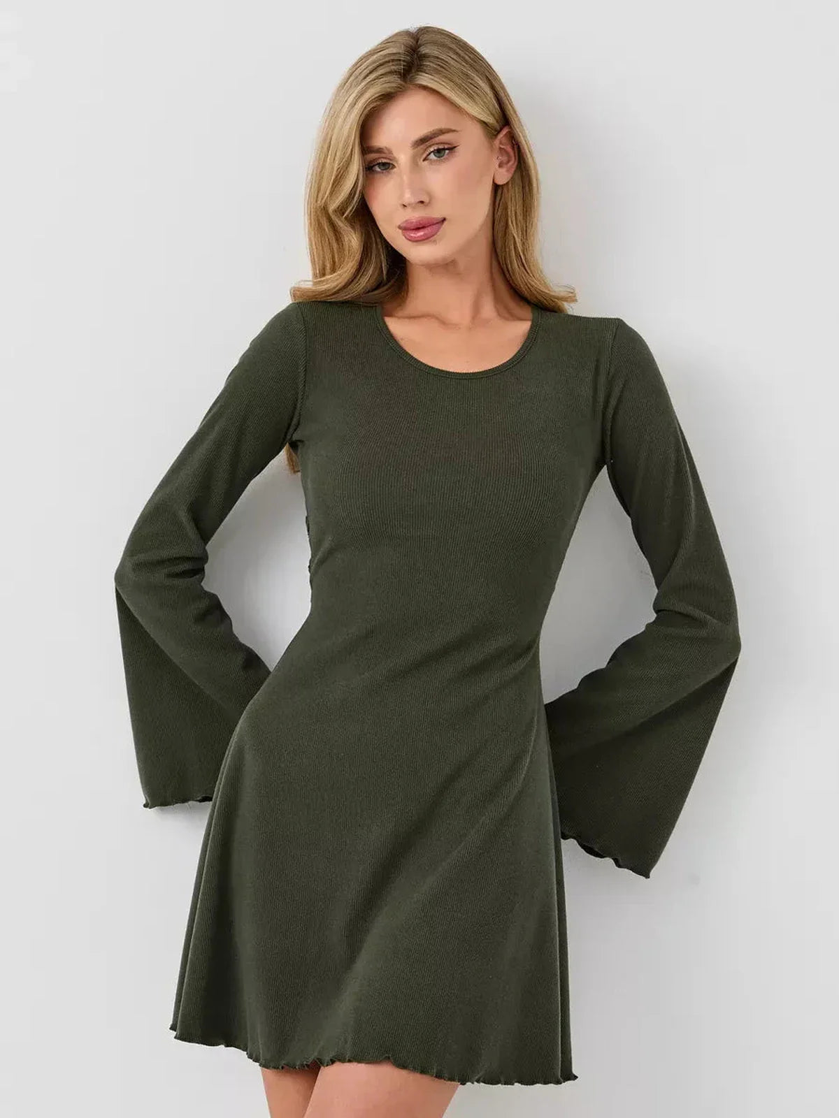 Model wearing the Ivy Bell mini dress with flared sleeves and A-line silhouette in olive green.