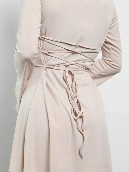 Back view of Cream Laced mini dress showcasing lace-up corset design and soft texture.