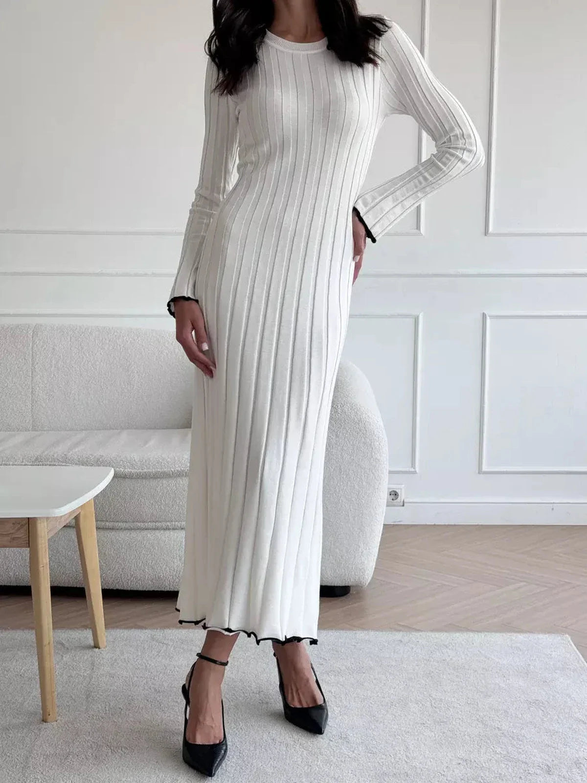 Ivory Grace Maxi Dress featuring ribbed texture, long sleeves, and delicate ruffle trim for elegant movement.