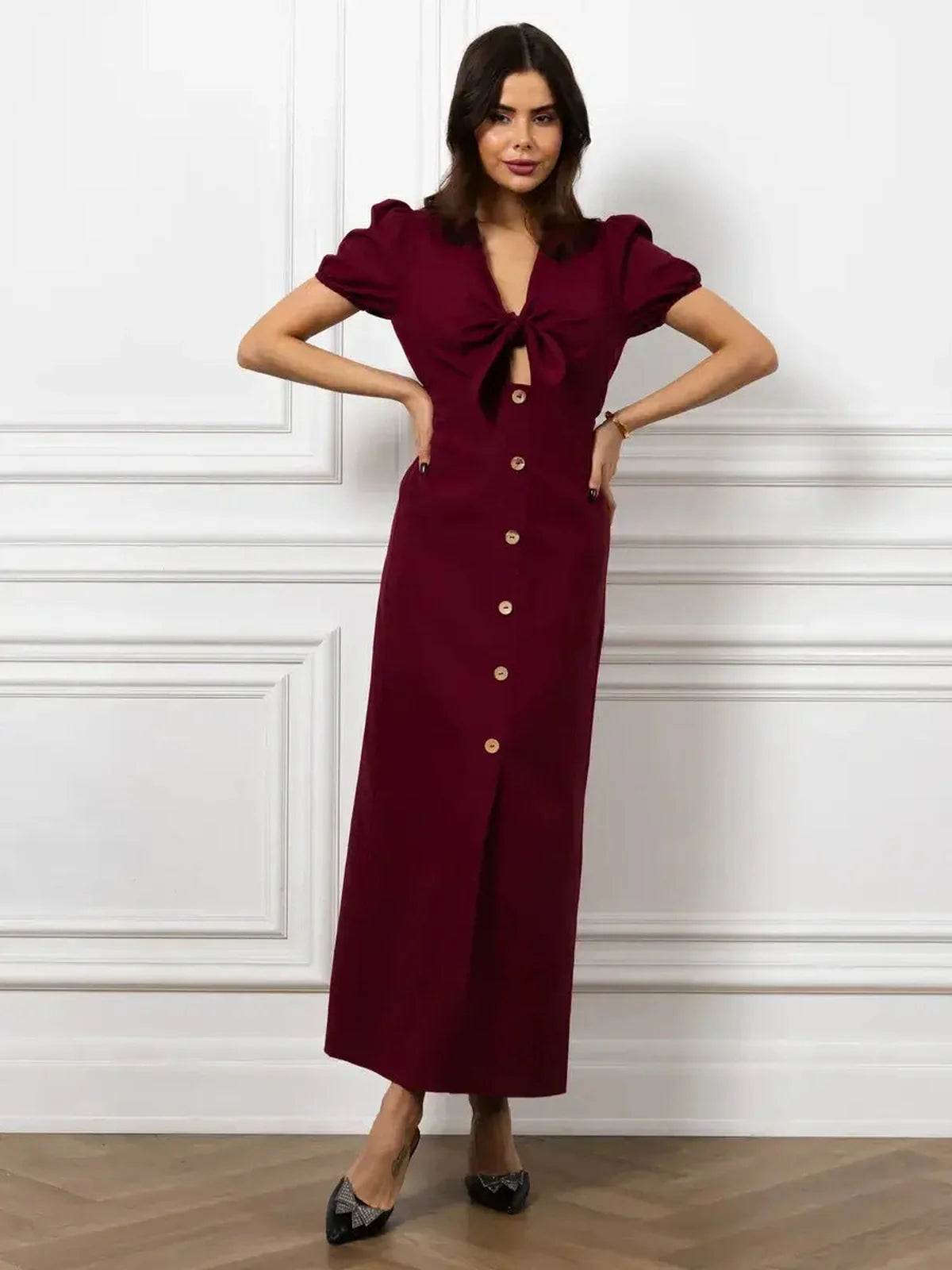 Elegant merlot maxi dress featuring a front bow, button detail, and puff sleeves for a stunning silhouette.