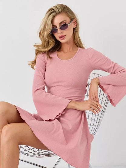 Model wearing a Blush Flare mini dress with flared bell sleeves, showcasing soft elegance in pink.