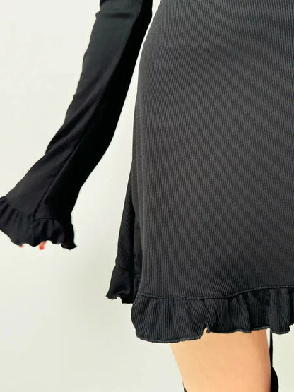 Detail of the Velvet Lace Mini showcasing textured ribbed fabric and playful ruffle hem for a chic look.