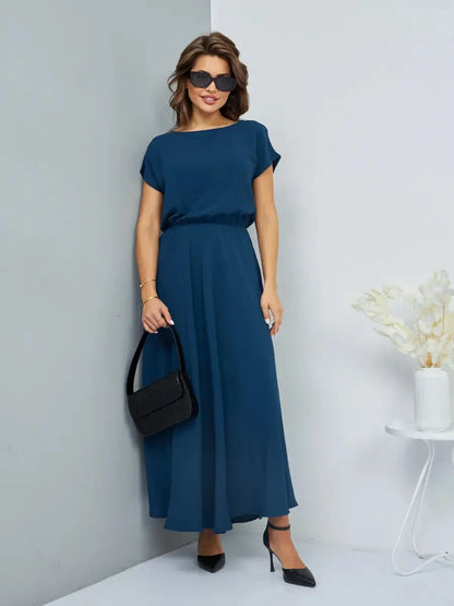 Model wearing the Verona Maxi Dress in blue, showcasing its flowy silhouette and elegant style.