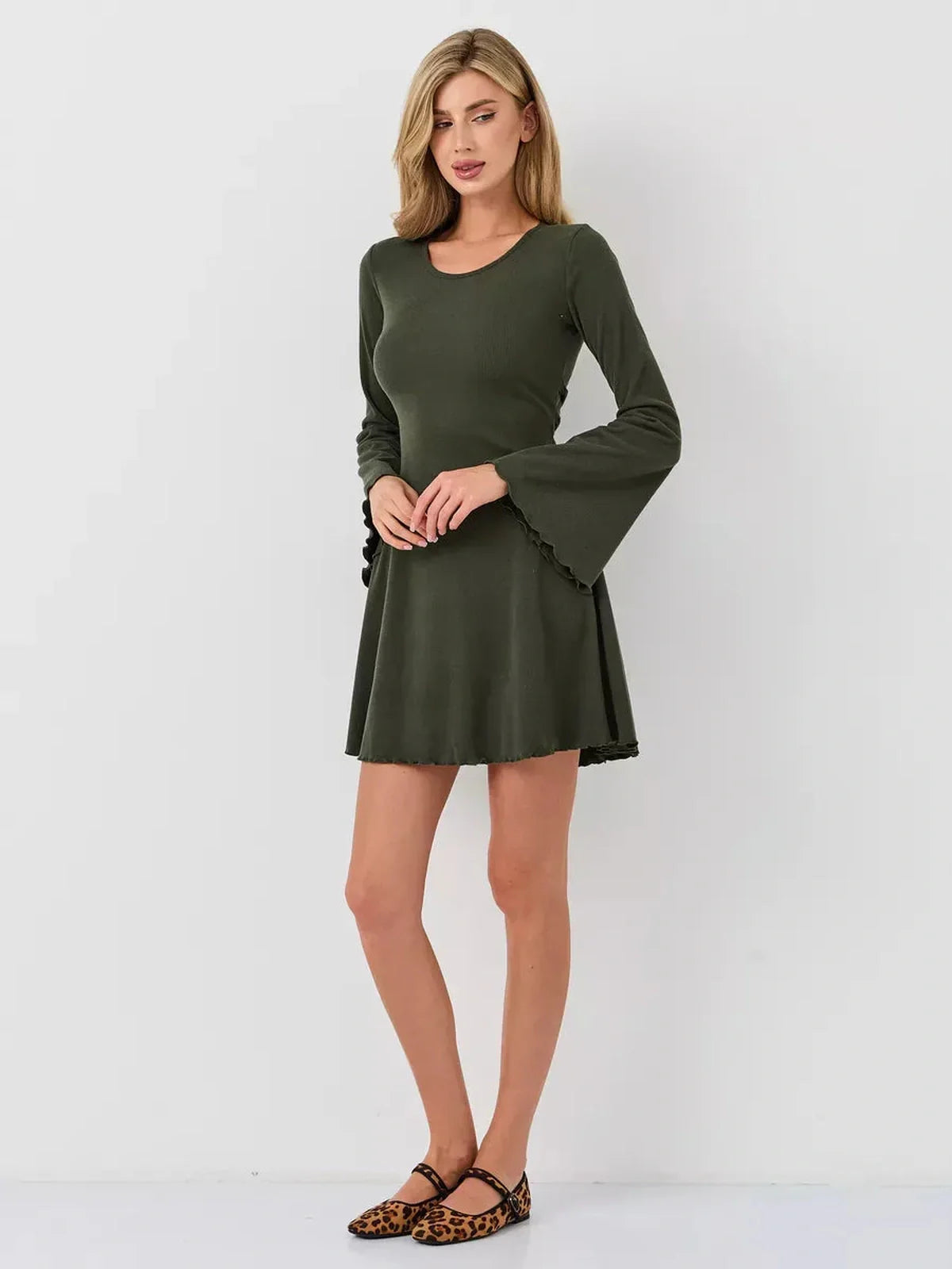 Model wearing Ivy Bell mini dress with flared bell sleeves and A-line silhouette in olive green.