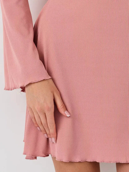Close-up of the Blush Aura mini dress showcasing its pink ribbed fabric and softly flared hemline.