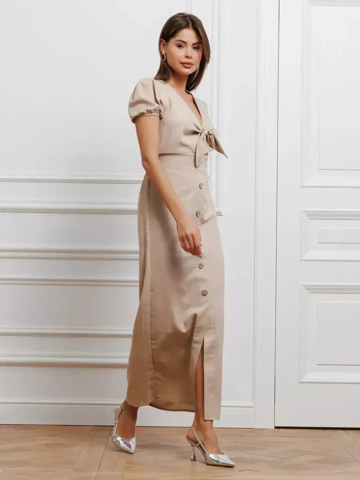 Model wearing the Serene Bond Maxi Dress with puff sleeves and waist tie, showcasing its elegant design in a neutral tone.