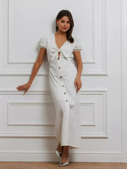 White maxi dress with tie-front, puff sleeves, and button-down skirt, exuding minimalist elegance and sophistication.